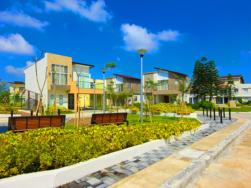 Lancaster New City Cavite courtyard at daytime, with landscaped gardens, elegant walkways, decorative fountains, and English Countryside inspired homes creating a peaceful community setting.