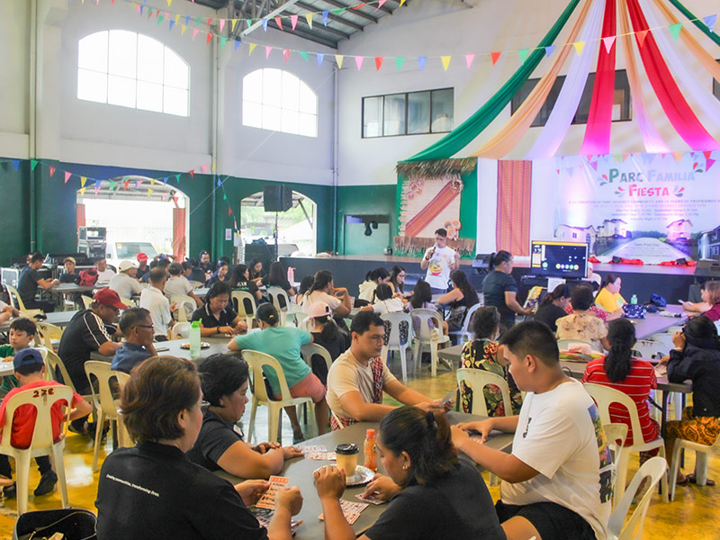 Residents of Parc Regency Residences in Pavia, Iloilo gather for a lively community fiesta, enjoying food, fellowship, and entertainment indoors.